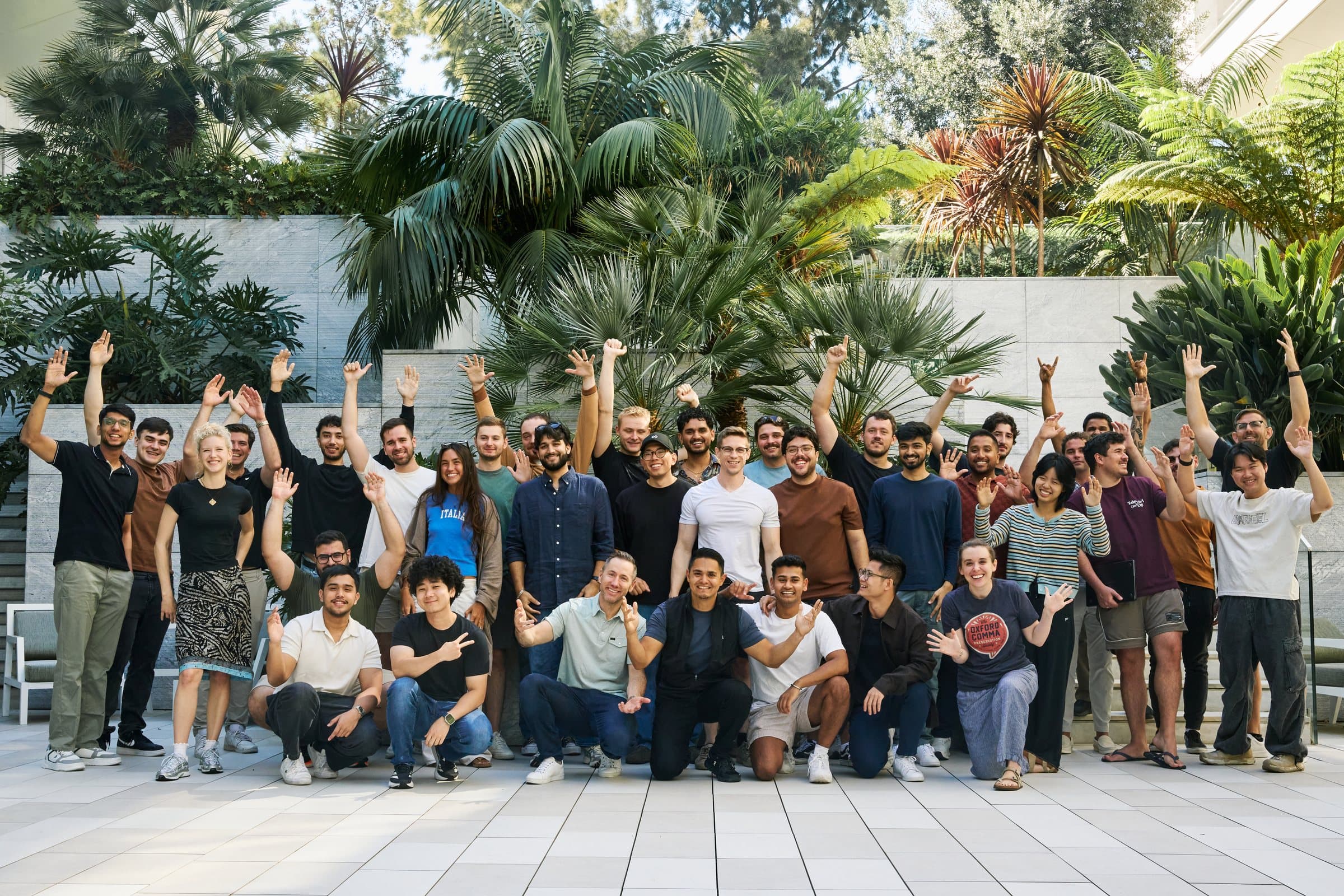 The Infisical team together in a courtyard, most of them waving at the camera